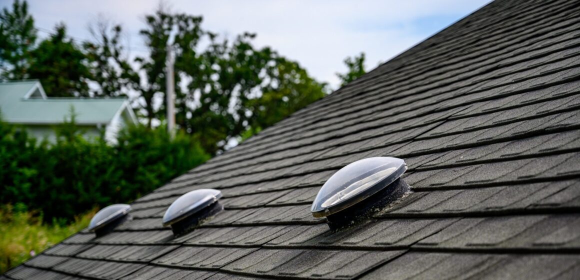 Dome shaped solar tube skylight on asphalt shingle roof