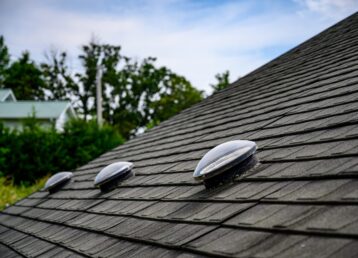 Dome shaped solar tube skylight on asphalt shingle roof